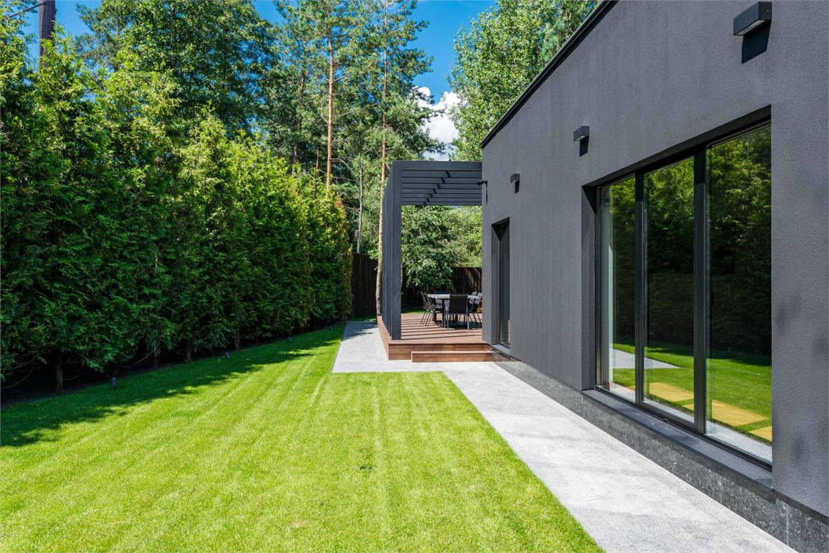 Contemporary house exterior with large windows and greenery