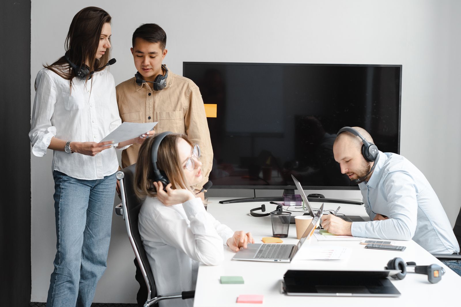 Support team members working with headsets and computers in an office