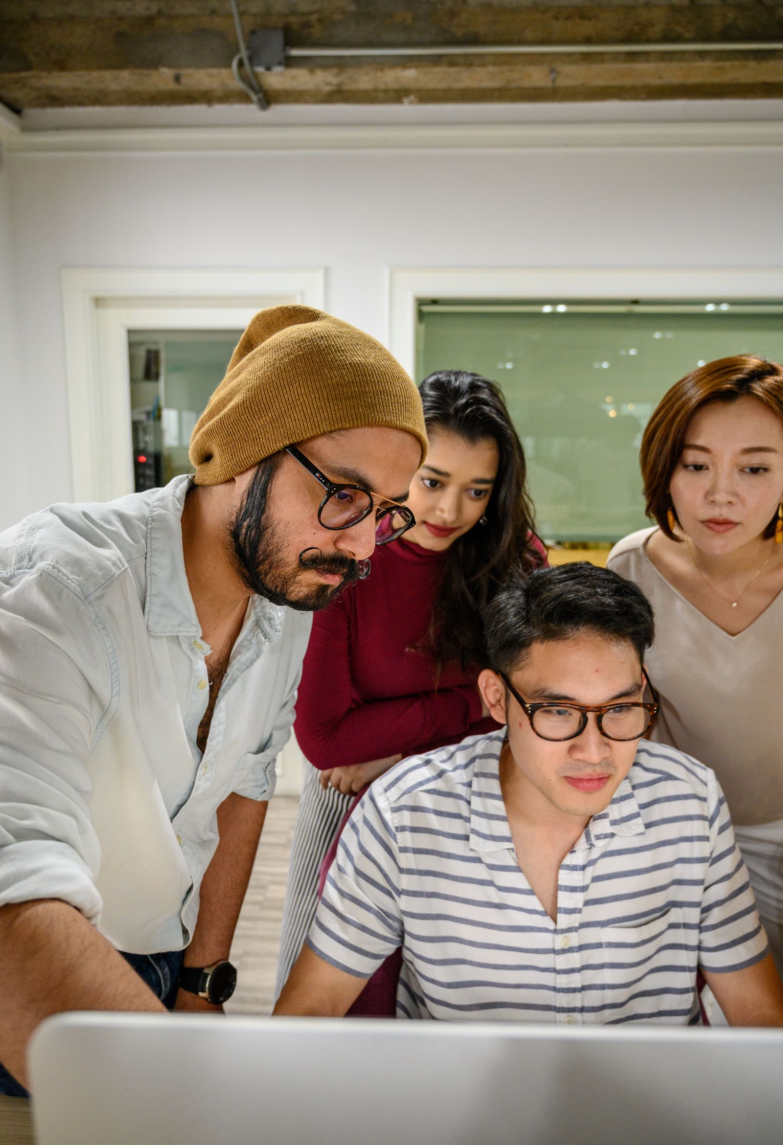 Diverse team of professionals collaborating around a computer